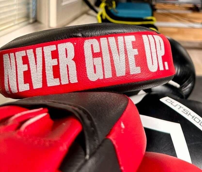 "Never give up" yazılı kırmızı boks eldivenleri